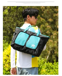 Détail du sac de voyage en nylon imperméable avec poches frontales et logo imprimé