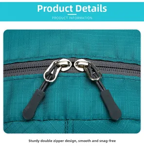 Detail of durable dual metal zippers on cyan plaid tear-resistant outdoor backpack fabric