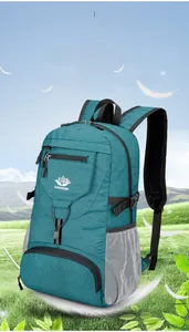 Gros plan d'un sac à dos de randonnée bleu-vert avec poches en filet sur l'herbe