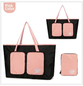 Détail du grand sac de voyage pliable avec un design contrasté rose et noir moderne