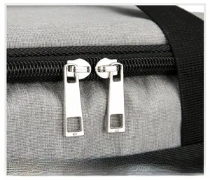 Détail des doubles fermetures éclair métalliques sur un sac isotherme en oxford gris