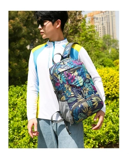 Détail du sac à dos de randonnée avec imprimé feuilles tropicales et poches zippées