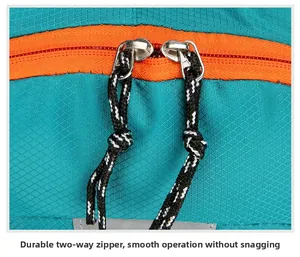 Detail of durable two-way metal zippers on a green ripstop nylon outdoor backpack
