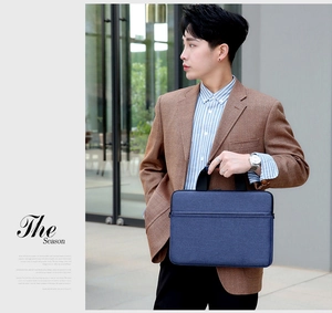 Slim navy business laptop bag with textured fabric and durable black carrying handles