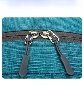 Gros plan sur les fermetures éclair doubles et le tissu texturé du sac de randonnée cyan