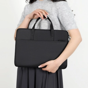 Sacoche ordinateur noire minimaliste avec poignées, portée par un mannequin sur fond blanc