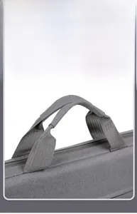 Detail of comfortable padded fabric handles on a gray laptop bag with shock protection