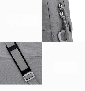 Detail view of durable metal zippers and adjustable woven strap on a gray laptop bag