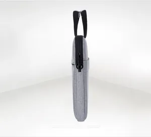 Slim side profile of grey fabric laptop bag featuring black handle and zipper details