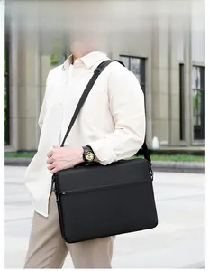 Business laptop bag in black matte fabric shown carried by a model in an urban setting