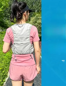 Vista posteriore di una donna con gilet da running grigio leggero e tessuto a rete traspirante
