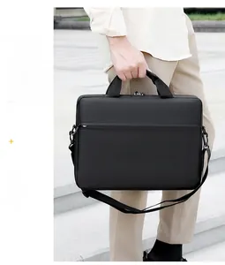Minimalist black laptop bag with padded handles and detachable nylon shoulder strap