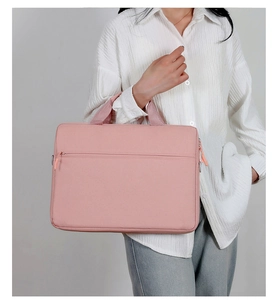 Pink minimalist laptop bag with front zipper pocket held by model in business setting