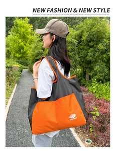 Detail of waterproof nylon travel bag in orange and black with mountain logo