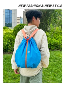 Detail of blue foldable sports backpack with orange straps and central zipper feature
