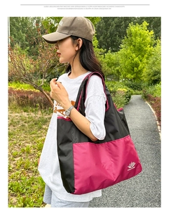 Outdoor model shot of high capacity color block travel bag with wide shoulder straps