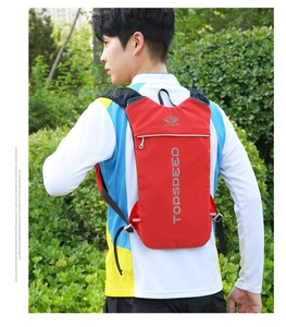 Détail du sac à dos de running rouge léger avec bandes réfléchissantes de sécurité