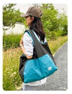 Outdoor close-up of a foldable large-capacity travel tote bag with VANAHEIMR logo