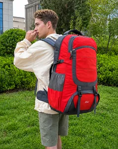 Outdoor 85L hiking backpack in red and grey nylon shown on model in a park