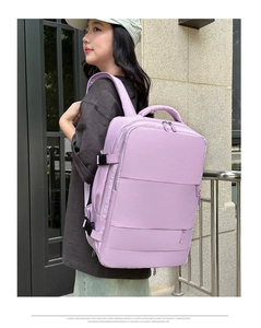 Side view of large purple travel backpack with multiple compartments on a model