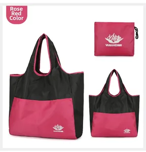 Detail view of foldable rose red travel bag featuring reinforced handles and Vanaheimr logo