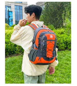 Outdoor hiking backpack in orange and grey nylon fabric shown in professional use