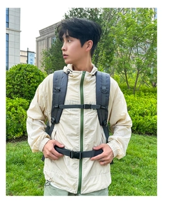 Detail of ergonomic padded shoulder straps and chest buckle on gray outdoor backpack