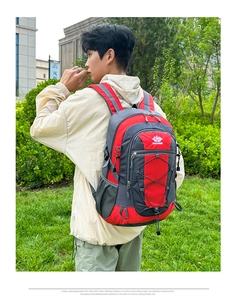 Outdoor hiking backpack in red and grey featuring bungee cords and side mesh pockets