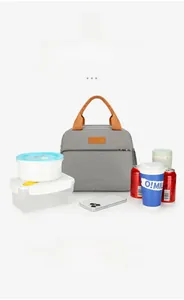 Close-up of gray insulated lunch bag showing front pocket storage and orange handles