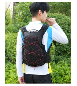 Outdoor hydration vest for running with red bungee cords and mesh side pockets on a male model