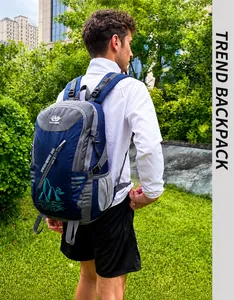 Side view of a blue and grey outdoor hiking backpack worn by a male model in the park