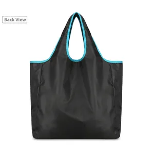 Back view of foldable black nylon travel tote bag with vibrant blue trim reinforcement