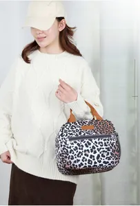 Detail of leopard print insulated lunch bag with woven handles and side mesh pocket