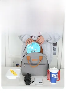 Detailed view of grey oxford lunch bag capacity with side pocket and brown handles