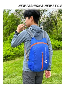 Blauwe waterdichte opvouwbare rugzak met oranje rits tijdens outdoor wandelen
