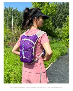 Detail of purple hydration vest with elastic cords worn by a female runner outdoors