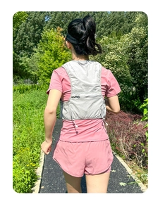 Vista posteriore di un gilet da corsa grigio traspirante con tasca a zip e coulisse