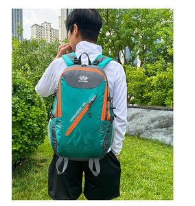Randonneur portant un sac à dos de randonnée 40L imperméable vert sur l'herbe