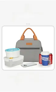 Detail of grey oxford fabric lunch bag with orange handles next to a meal container