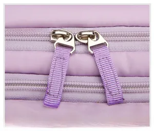Close-up of durable dual purple zippers and silver metal pullers on travel backpack
