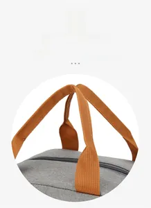 Detail of the reinforced orange padded handle and smooth zipper on the grey lunch bag