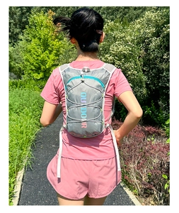 Detail view of the lightweight hydration pack with grey fabric and turquoise zippers