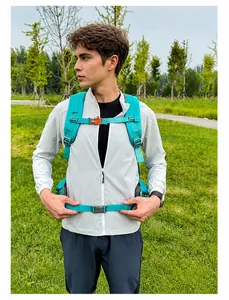 Outdoor hiking backpack with orange buckles and ergonomic chest strap on a light grey jacket