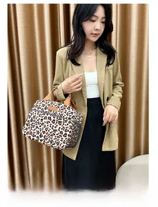 Detailed close-up of leopard print insulated lunch bag with brown woven handles