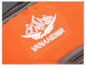 Close-up of VANAHEIMR logo embroidery on orange and gray durable nylon hiking backpack