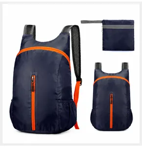 Detail van de donkerblauwe opvouwbare rugzak met oranje ritsen en compacte opbergtas