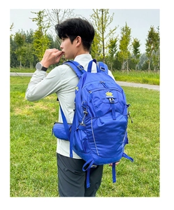 Detail of blue outdoor hiking backpack with adjustable straps and yellow peak logo