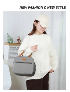 Gray Oxford fabric insulated lunch bag with brown leather handles held by a model
