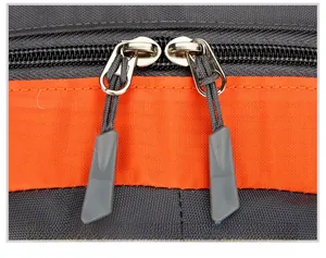 Macro detail of high-quality dual metal zippers with non-slip pullers on hiking backpack