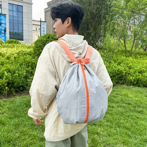 Lightweight water-resistant foldable grey backpack with orange accents and zippers